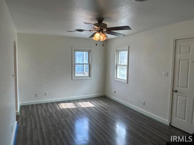 unfurnished room with a textured ceiling, ceiling fan, and dark wood-type flooring