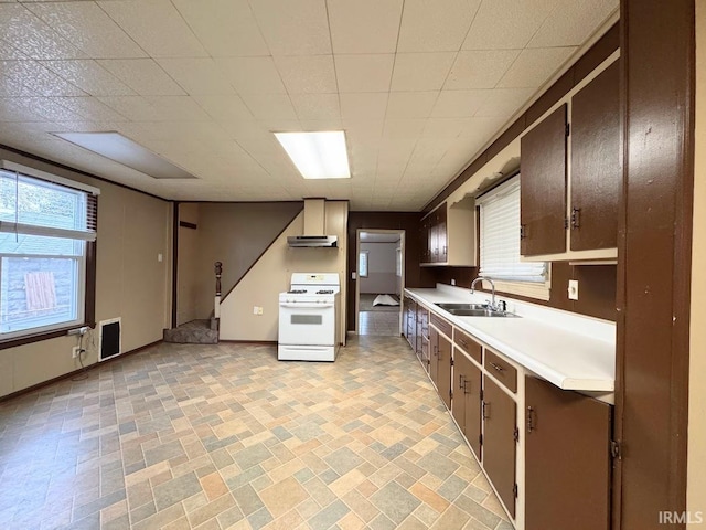 kitchen featuring white range with gas stovetop, sink, wall chimney exhaust hood, and plenty of natural light