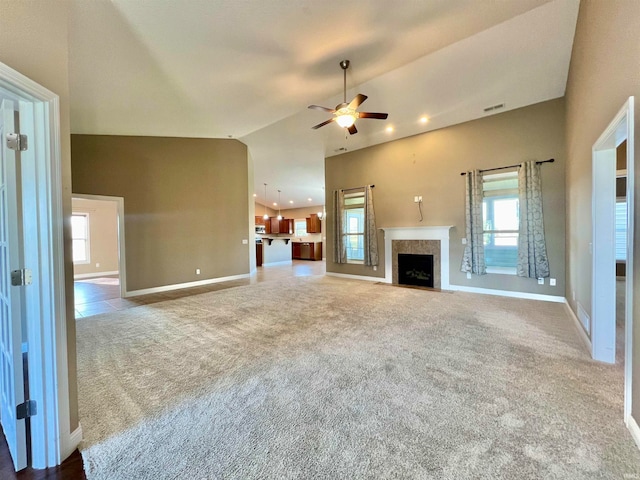 unfurnished living room featuring vaulted ceiling, carpet flooring, and ceiling fan