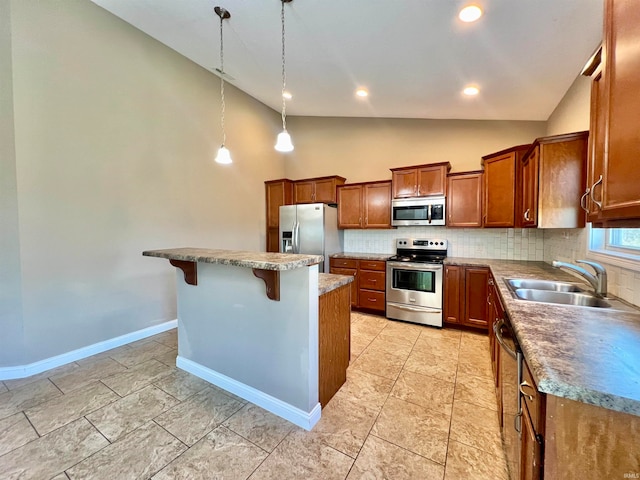 kitchen with appliances with stainless steel finishes, a kitchen breakfast bar, sink, pendant lighting, and a center island