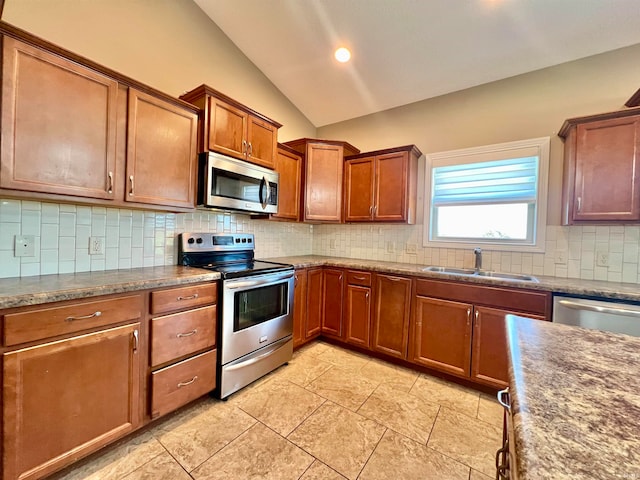 kitchen featuring lofted ceiling, light tile patterned floors, backsplash, sink, and stainless steel appliances