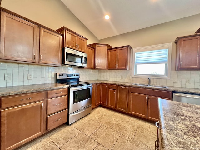 1793 Breckenridge Pass, Fort Wayne, IN 46845 - kitchen featuring decorative backsplash, brown cabinetry, vaulted ceiling, a sink, and stainless steel appliances