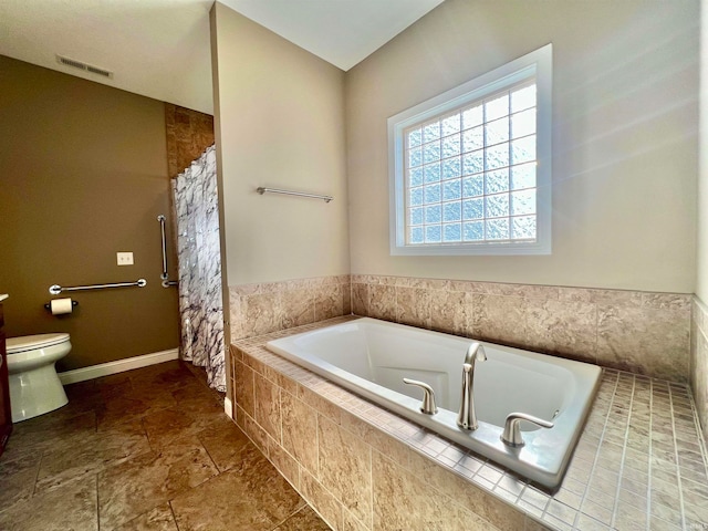 bathroom featuring toilet and separate shower and tub