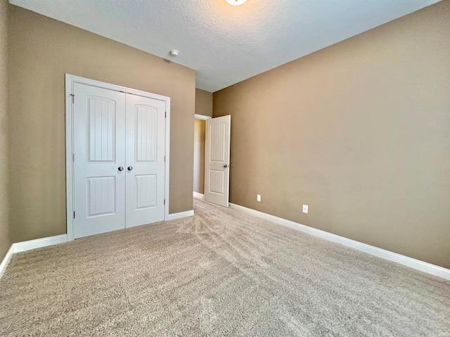 unfurnished bedroom with a closet, a textured ceiling, and carpet flooring