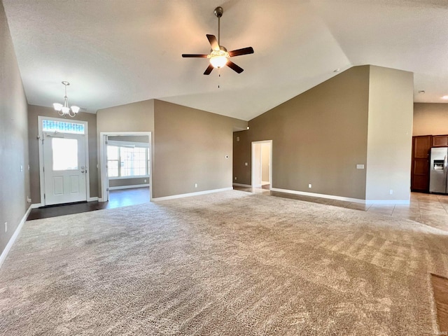 unfurnished living room featuring high vaulted ceiling, light colored carpet, and ceiling fan with notable chandelier