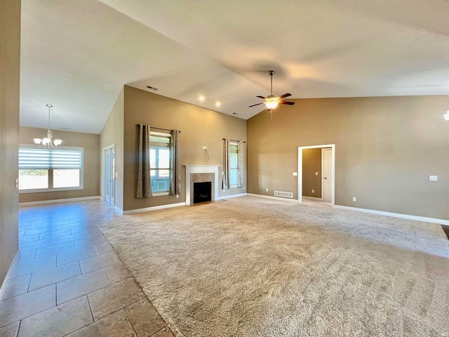 unfurnished living room with light carpet, high vaulted ceiling, and ceiling fan with notable chandelier