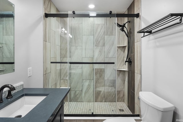 bathroom featuring vanity, toilet, and an enclosed shower