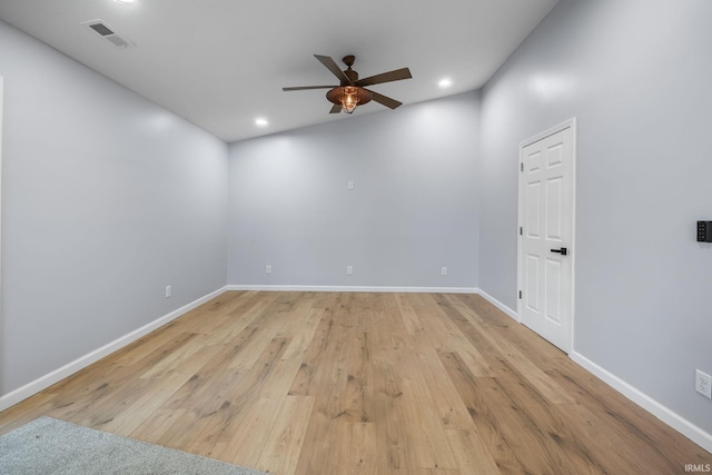 spare room featuring light hardwood / wood-style flooring, vaulted ceiling, and ceiling fan