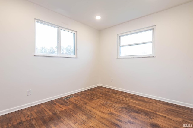 unfurnished room with dark wood-type flooring