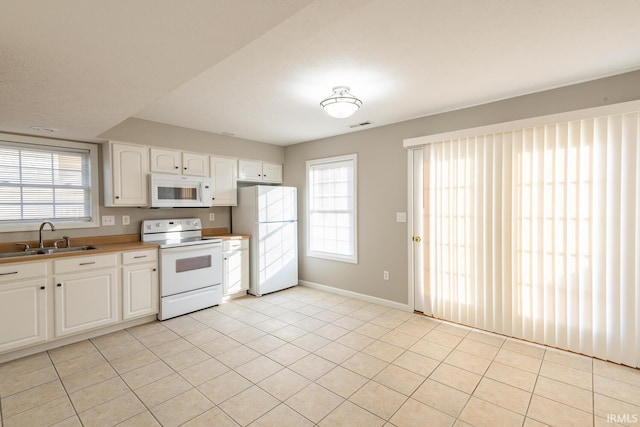 kitchen featuring white cabinets, sink, plenty of natural light, and white appliances