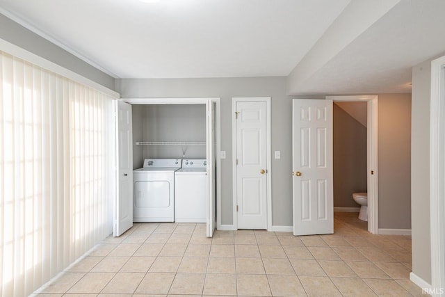 washroom with washing machine and dryer and light tile patterned floors