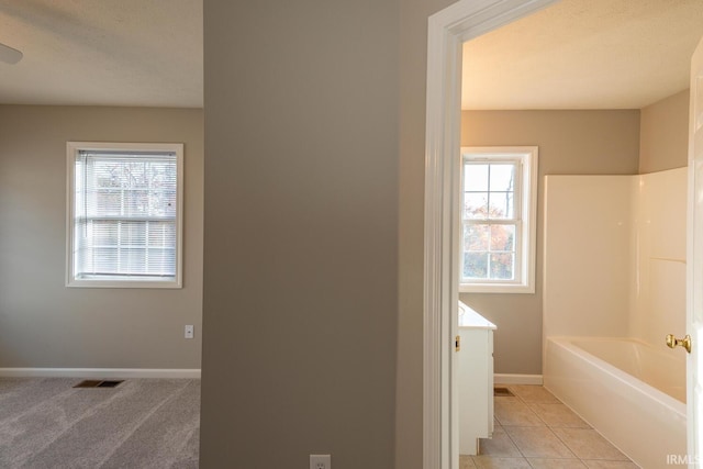 bathroom featuring a textured ceiling and tile patterned flooring