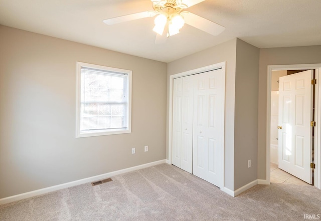 unfurnished bedroom featuring a closet, ceiling fan, and light carpet