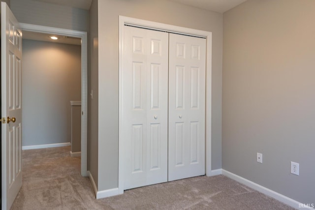 unfurnished bedroom featuring a closet and light carpet