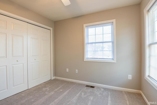 unfurnished bedroom with a closet, ceiling fan, and light colored carpet