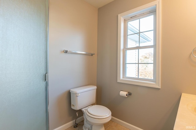 bathroom with a shower with door, toilet, tile patterned floors, and plenty of natural light