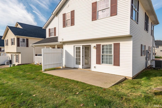 rear view of house with a patio, central AC, and a yard