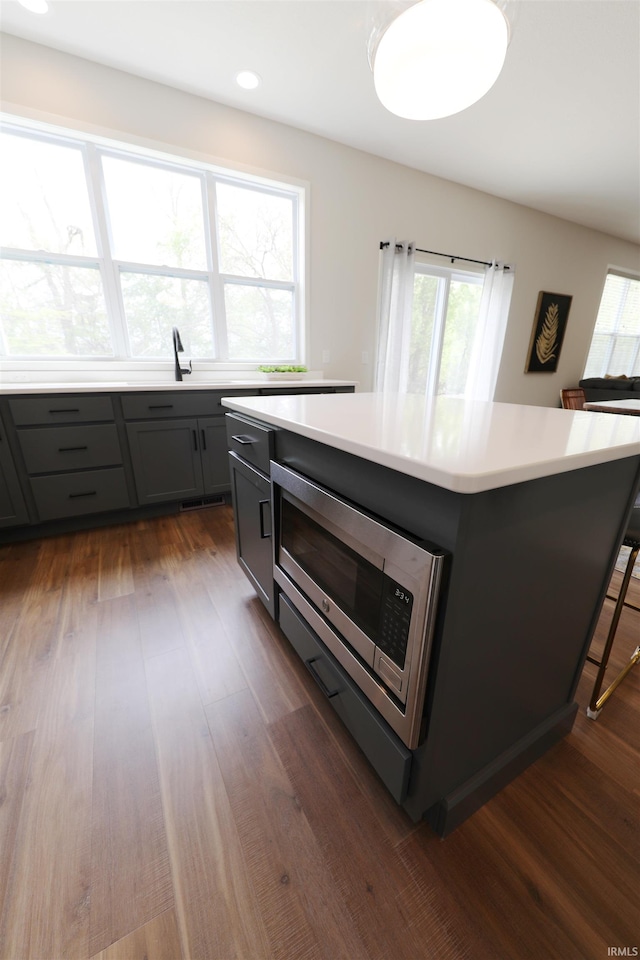 kitchen featuring dark hardwood / wood-style flooring, a kitchen island, and plenty of natural light