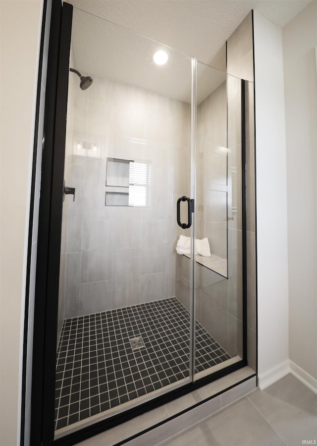 bathroom featuring a shower with door and tile patterned floors