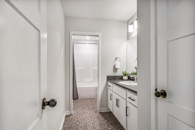 bathroom with shower / tub combo with curtain, vanity, and a textured ceiling