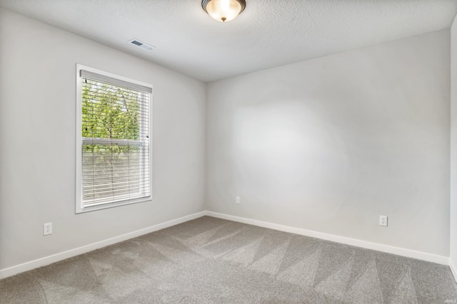 empty room featuring carpet floors and a textured ceiling