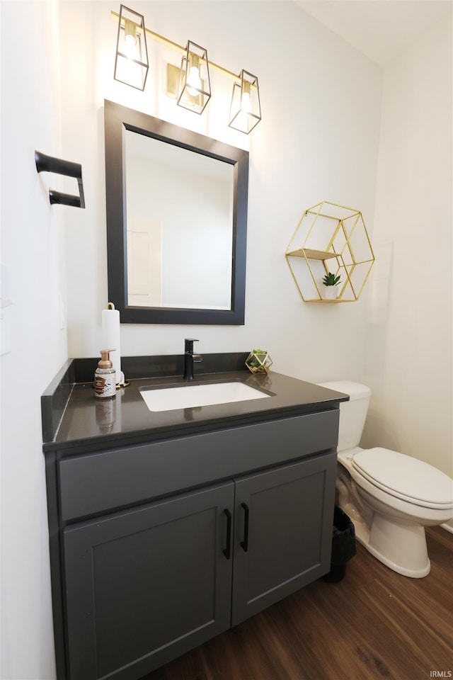 bathroom featuring vanity, toilet, and hardwood / wood-style floors