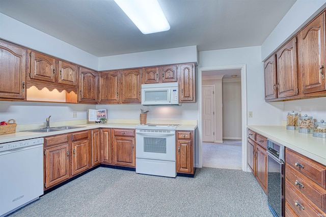 kitchen featuring sink, light colored carpet, and white appliances