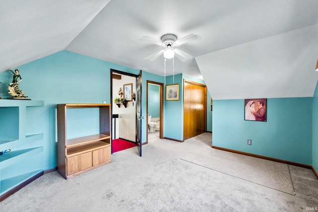 unfurnished bedroom featuring connected bathroom, ceiling fan, lofted ceiling, and carpet floors