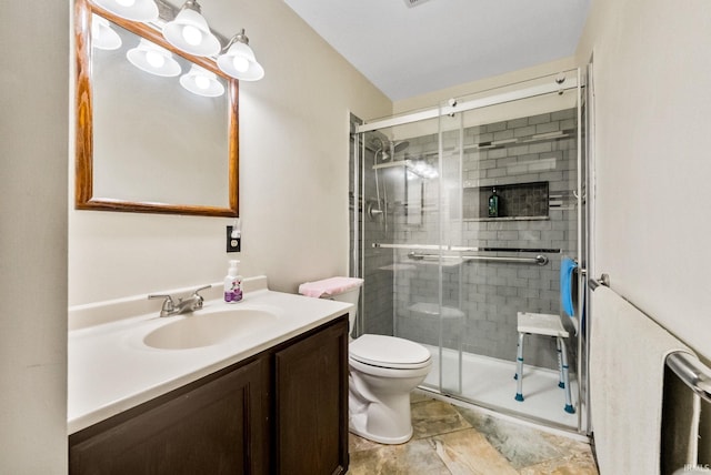 bathroom featuring vanity, toilet, and walk in shower