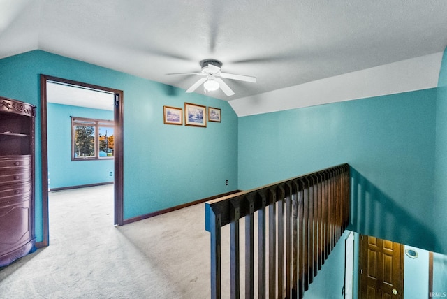 corridor featuring vaulted ceiling and light colored carpet