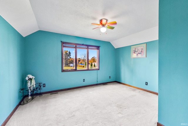 additional living space featuring ceiling fan, a textured ceiling, vaulted ceiling, and light colored carpet