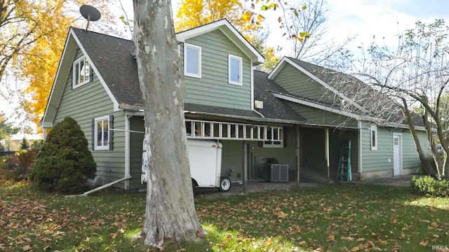 back of house featuring a yard and central AC unit