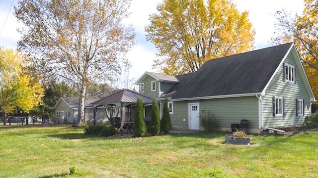 back of house with a gazebo and a yard