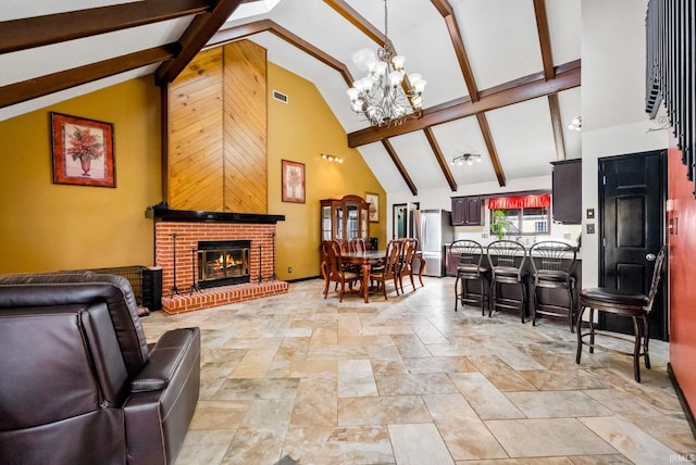 living room with an inviting chandelier, beam ceiling, a brick fireplace, and high vaulted ceiling