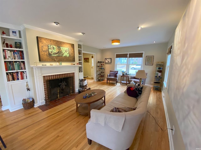 living room with light hardwood / wood-style flooring, a brick fireplace, and built in shelves