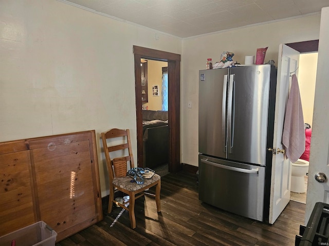 kitchen with ornamental molding, dark wood-type flooring, and stainless steel refrigerator