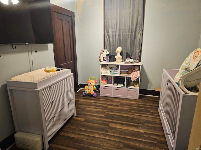 interior space with a crib and dark wood-type flooring