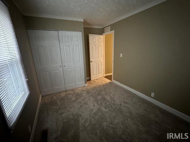 unfurnished bedroom featuring a textured ceiling, carpet flooring, and a closet