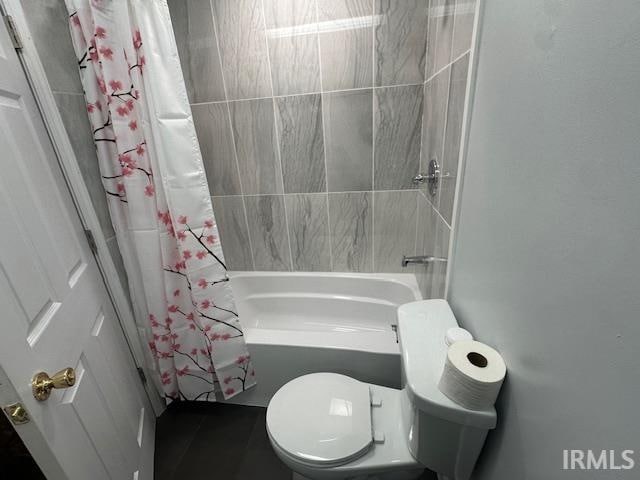 bathroom with shower / bath combination with curtain and toilet