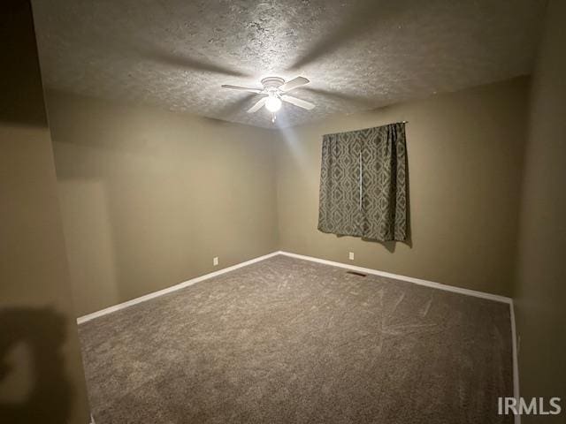 spare room featuring a textured ceiling, carpet flooring, and ceiling fan