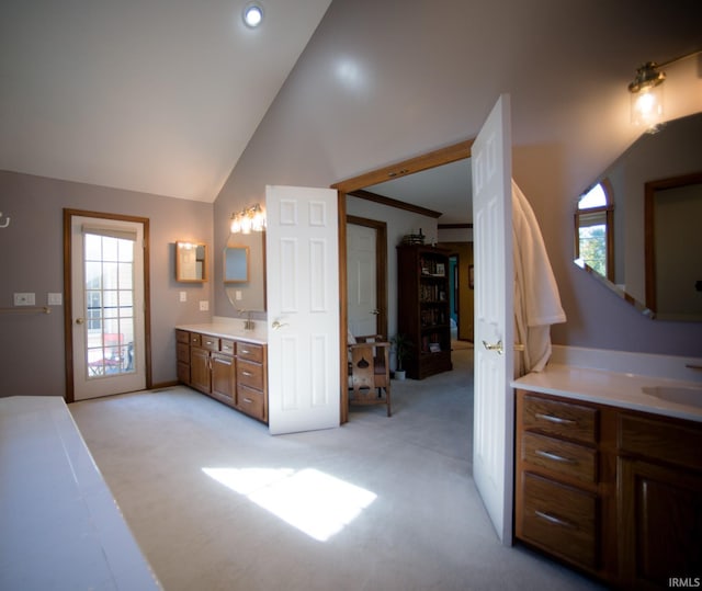 bathroom featuring vanity, lofted ceiling, and a healthy amount of sunlight