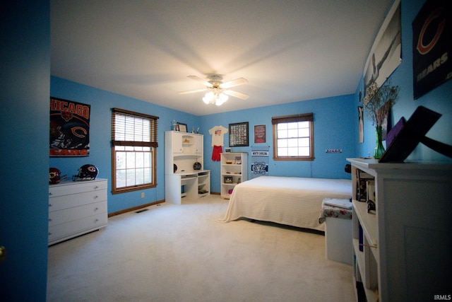 carpeted bedroom with multiple windows and ceiling fan