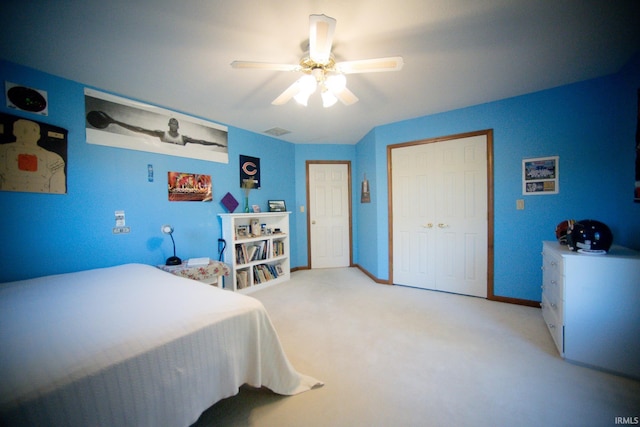 carpeted bedroom featuring a closet and ceiling fan