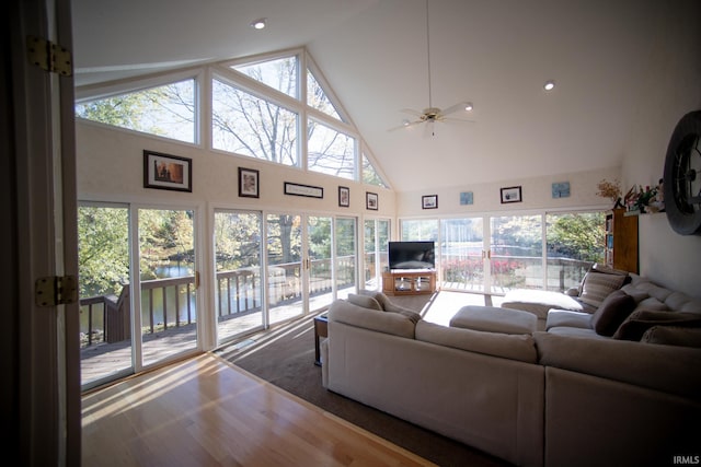 living room with a healthy amount of sunlight, high vaulted ceiling, and ceiling fan