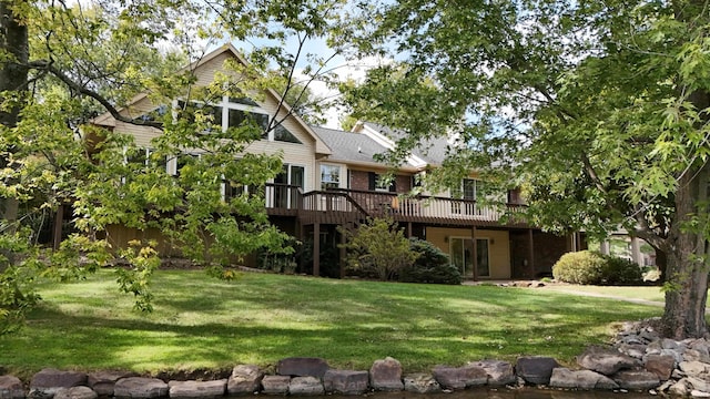 rear view of property with a deck and a lawn