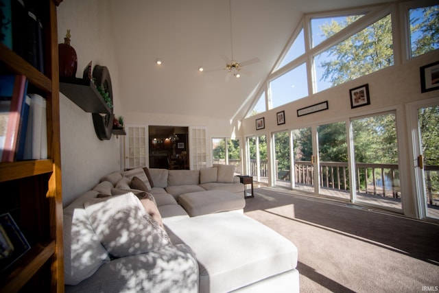 carpeted living room featuring ceiling fan, high vaulted ceiling, and a wealth of natural light