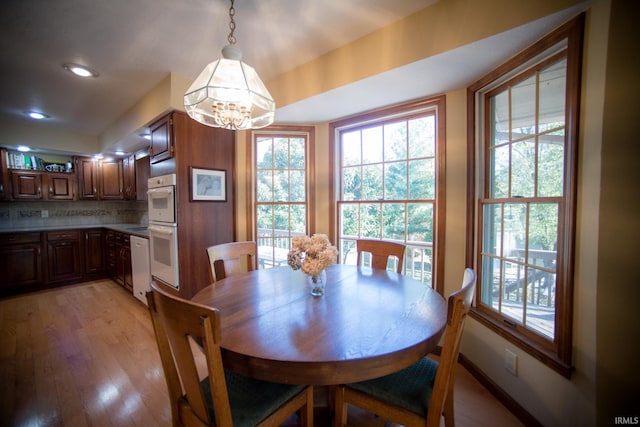 dining space with a notable chandelier and light hardwood / wood-style floors