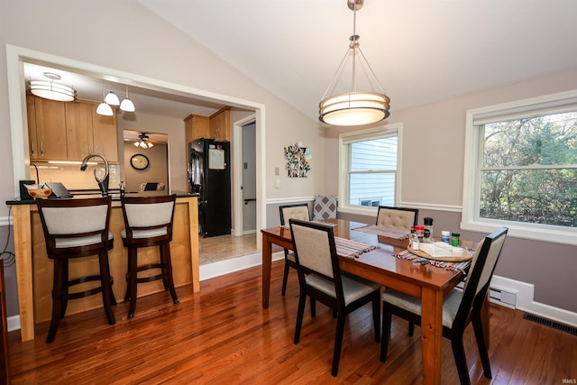 dining room featuring hardwood / wood-style flooring, lofted ceiling, and ceiling fan