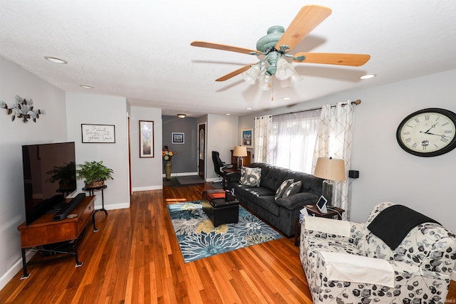 living room with dark hardwood / wood-style flooring and ceiling fan