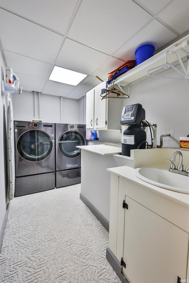 washroom with cabinets, carpet floors, sink, and washing machine and clothes dryer